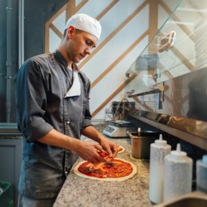 The chef prepares pizza. Catering kitchen work.
